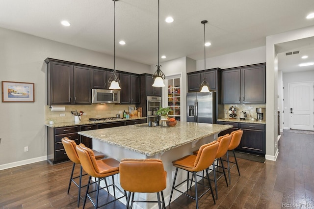 21376 E Union Pl, Aurora, CO 80015 - kitchen with stainless steel appliances, a kitchen island, dark wood-type flooring, baseboards, and recessed lighting