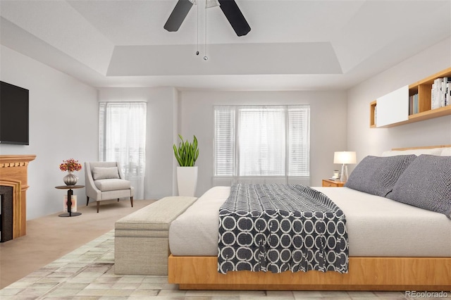 bedroom featuring a tray ceiling, ceiling fan, and carpet