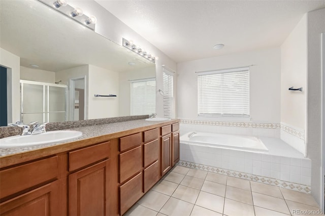 bathroom with tile patterned flooring, shower with separate bathtub, vanity, and a textured ceiling