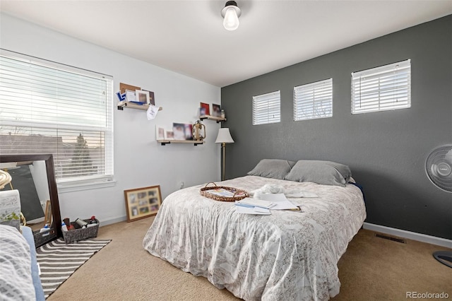 bedroom with multiple windows and carpet