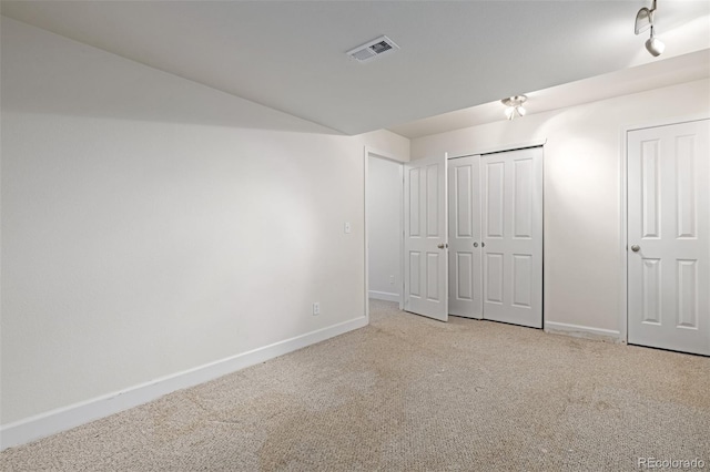 unfurnished bedroom with light carpet and a closet