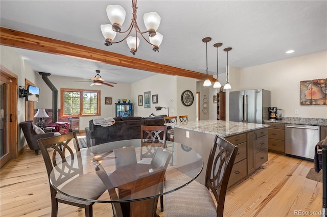 715 Clark Rd, Bailey, CO 80421 - dining space with a wood stove, beamed ceiling, light wood finished floors, ceiling fan, and a chandelier