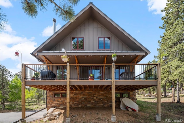 715 Clark Rd, Bailey, CO 80421 - rear view of property with board and batten siding, a deck, and stone siding
