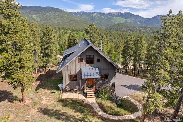 715 Clark Rd, Bailey, CO 80421 - view of front facade with a view of trees, a mountain view, and board and batten siding