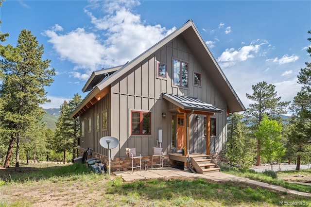715 Clark Rd, Bailey, CO 80421 - view of front facade featuring board and batten siding, a standing seam roof, a metal roof, and a patio area
