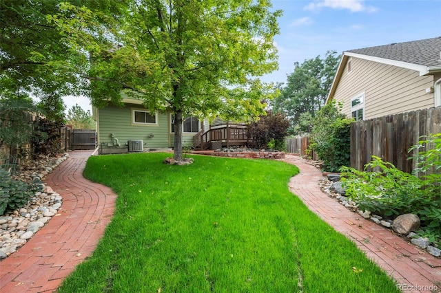 view of yard featuring a wooden deck and central air condition unit