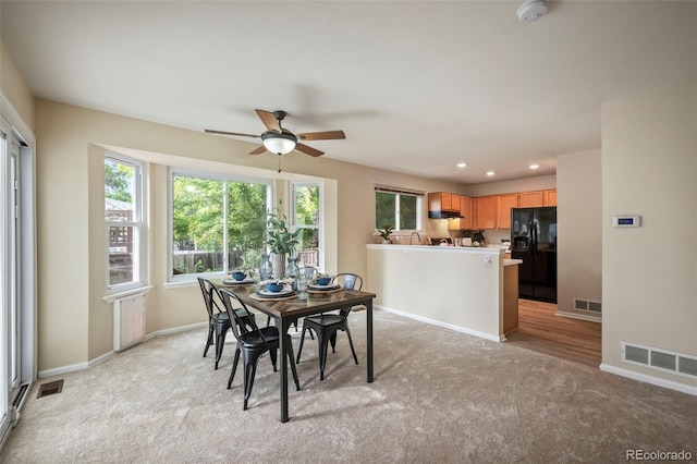 carpeted dining area featuring ceiling fan