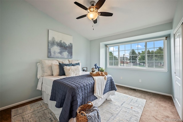 carpeted bedroom with vaulted ceiling and ceiling fan