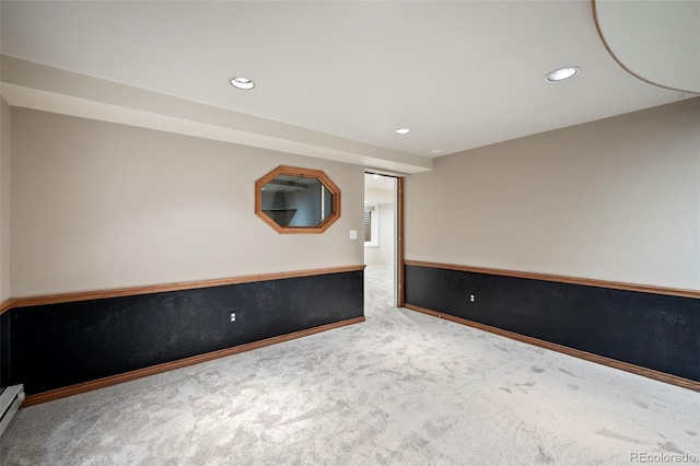 carpeted empty room featuring a baseboard heating unit