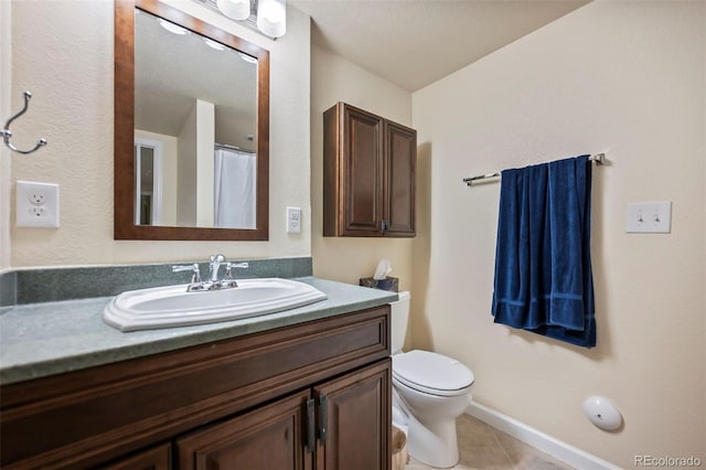 bathroom featuring vanity, tile patterned flooring, and toilet