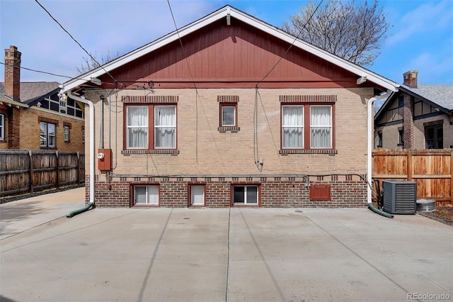 view of side of home featuring brick siding, central AC unit, and a patio area