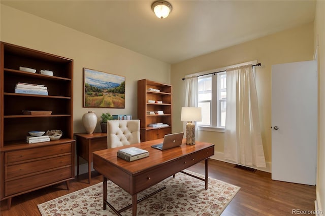home office with dark wood-style floors and baseboards