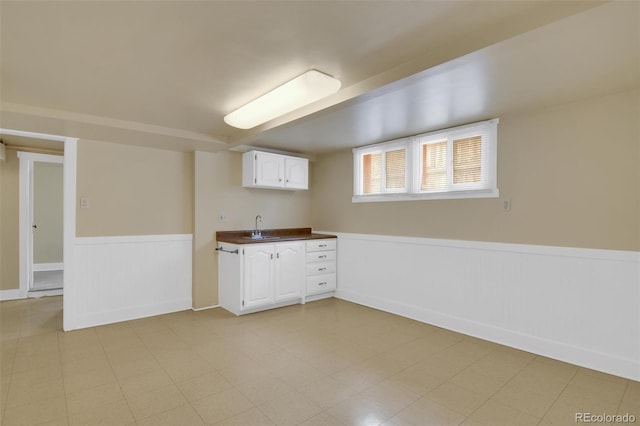 basement featuring a wainscoted wall and a sink