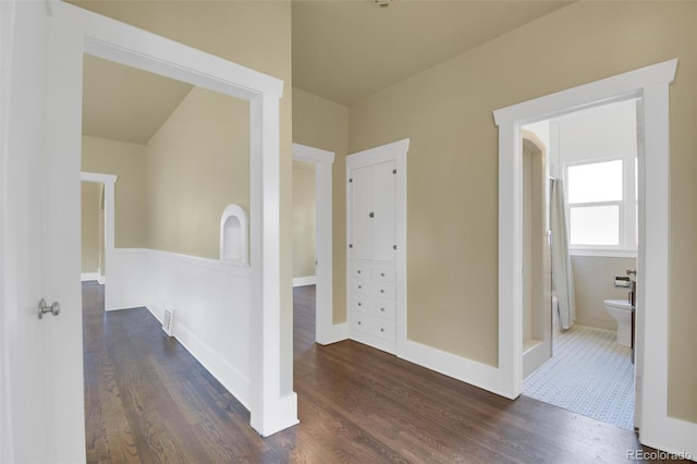 hallway with dark wood-type flooring and baseboards
