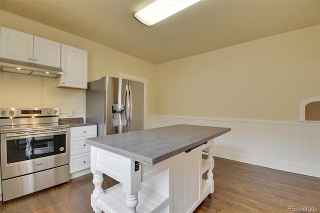 kitchen with appliances with stainless steel finishes, under cabinet range hood, dark countertops, and white cabinets