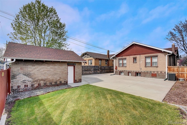 back of house featuring brick siding, a patio, cooling unit, and a chimney