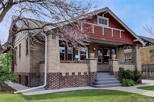 view of front of home featuring a porch and brick siding