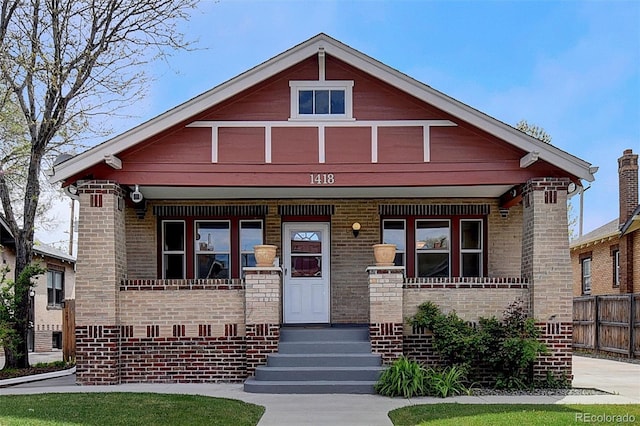 view of front of home with covered porch and brick siding