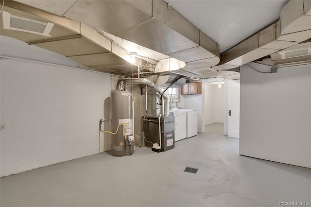 below grade area featuring water heater, independent washer and dryer, and heating unit