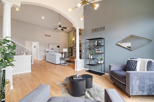 415 Butte Pkwy, Golden, CO 80403 - living area featuring decorative columns, a high ceiling, ceiling fan, light wood finished floors, and arched walkways