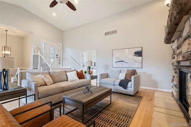 415 Butte Pkwy, Golden, CO 80403 - living area featuring high vaulted ceiling, light wood finished floors, a ceiling fan, a fireplace, and a chandelier