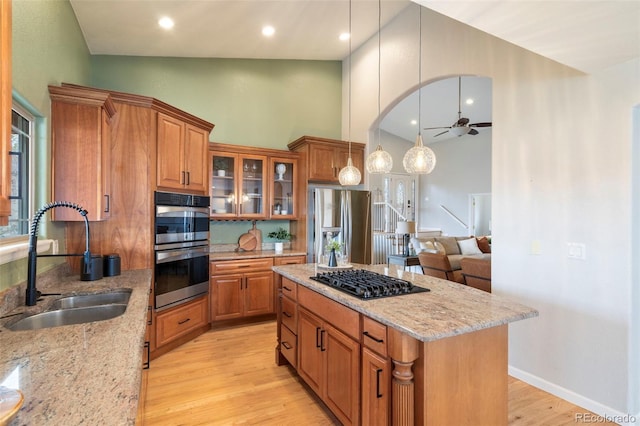 415 Butte Pkwy, Golden, CO 80403 - kitchen with a sink, stainless steel appliances, brown cabinets, a ceiling fan, and high vaulted ceiling