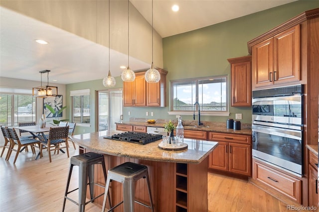 415 Butte Pkwy, Golden, CO 80403 - kitchen with stainless steel appliances, a sink, brown cabinetry, recessed lighting, and a towering ceiling