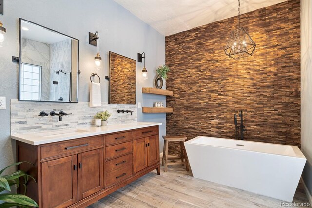 415 Butte Pkwy, Golden, CO 80403 - full bath featuring a soaking tub, double vanity, decorative backsplash, wood finished floors, and a chandelier