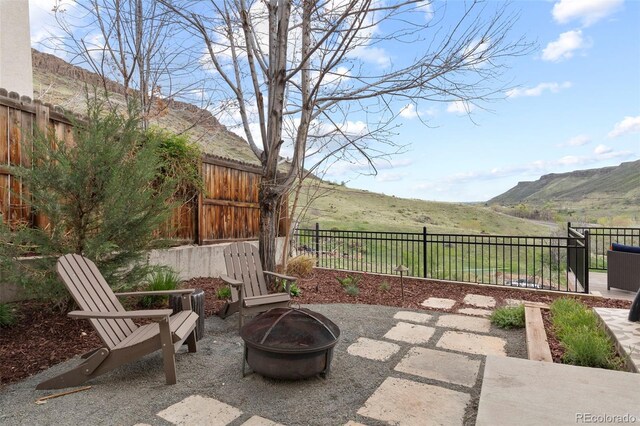 415 Butte Pkwy, Golden, CO 80403 - fenced backyard featuring an outdoor fire pit, a mountain view, and a patio