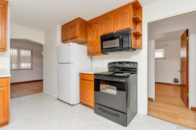 3515 Grape St, Denver, CO 80207 - kitchen with black appliances, light countertops, brown cabinets, and baseboards