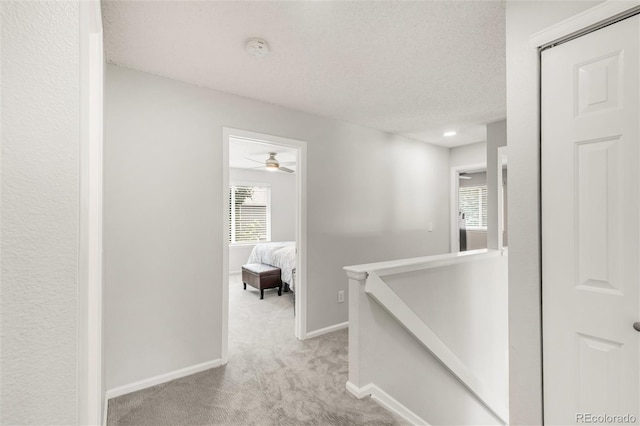 10591 Hyacinth St, Highlands Ranch, CO 80129 - hallway featuring an upstairs landing, carpet floors, baseboards, and a textured ceiling