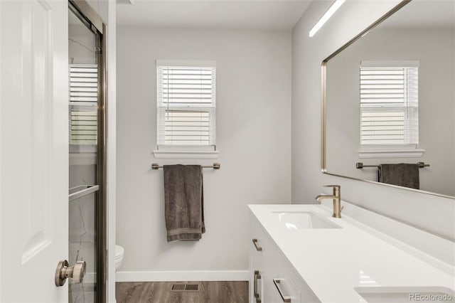10591 Hyacinth St, Highlands Ranch, CO 80129 - full bathroom featuring double vanity, toilet, wood finished floors, baseboards, and an enclosed shower