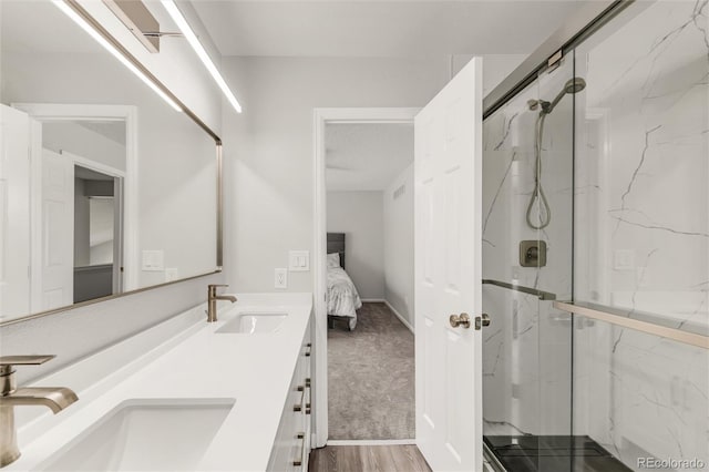 10591 Hyacinth St, Highlands Ranch, CO 80129 - ensuite bathroom featuring a marble finish shower, double vanity, and wood finished floors