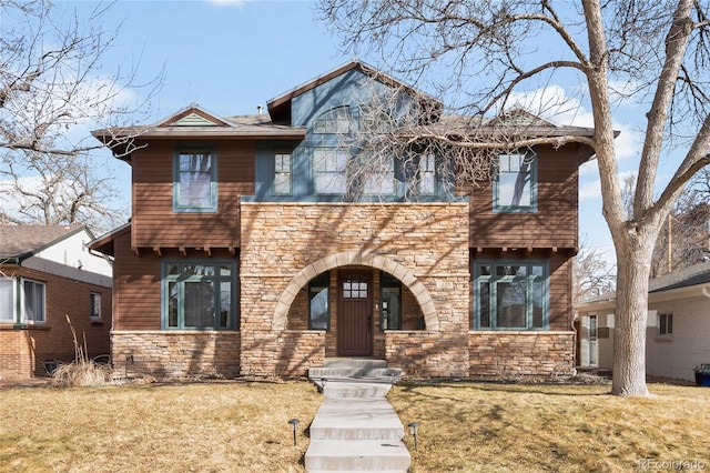 view of front of house featuring stone siding and a front yard