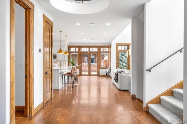 entryway with stairs, french doors, baseboards, and wood finished floors