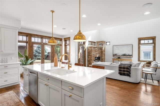 kitchen with dishwasher, open floor plan, a sink, and dark wood-style floors