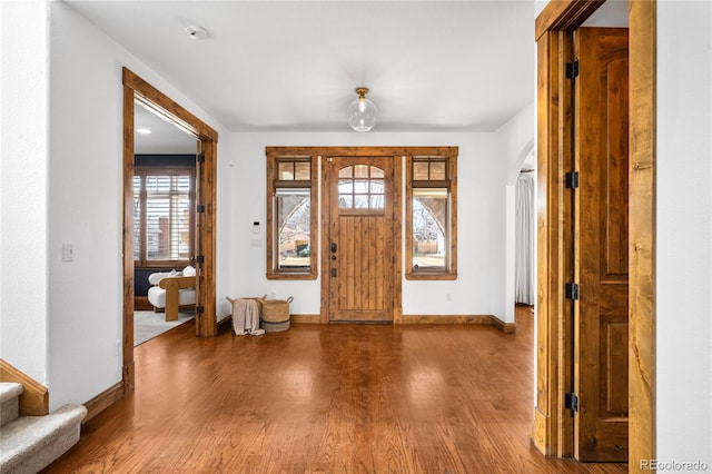 foyer with a healthy amount of sunlight, baseboards, and wood finished floors