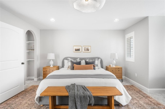 bedroom featuring arched walkways, recessed lighting, light carpet, and baseboards