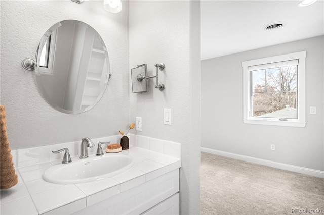 bathroom featuring visible vents, vanity, and baseboards