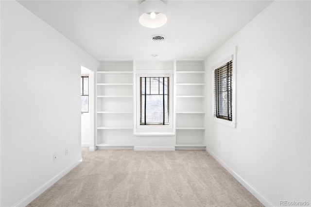 unfurnished room with light carpet, visible vents, and baseboards