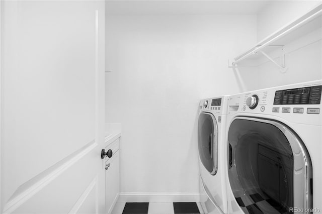 washroom featuring laundry area, baseboards, and washing machine and clothes dryer