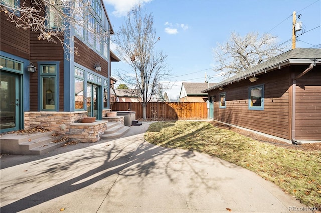 exterior space with stone siding and fence