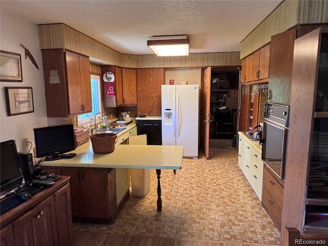 3910 E Orchard Rd, Centennial, CO 80121 - kitchen with white fridge with ice dispenser, light countertops, a peninsula, a kitchen bar, and oven