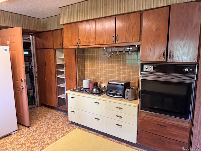 3910 E Orchard Rd, Centennial, CO 80121 - kitchen featuring black oven, freestanding refrigerator, stovetop, light countertops, and decorative backsplash