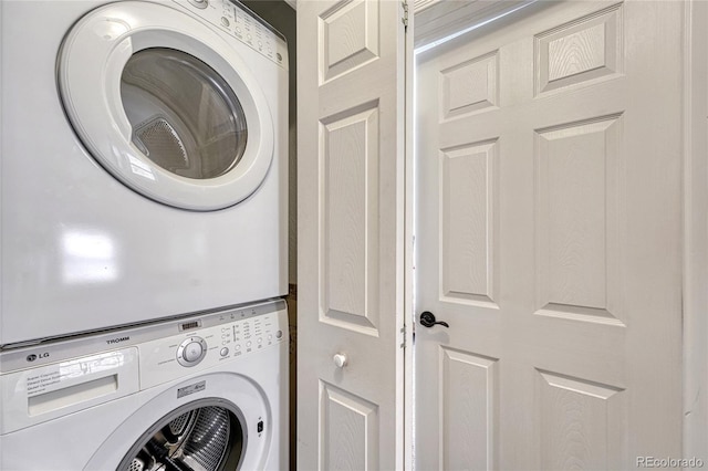 washroom featuring stacked washer / drying machine