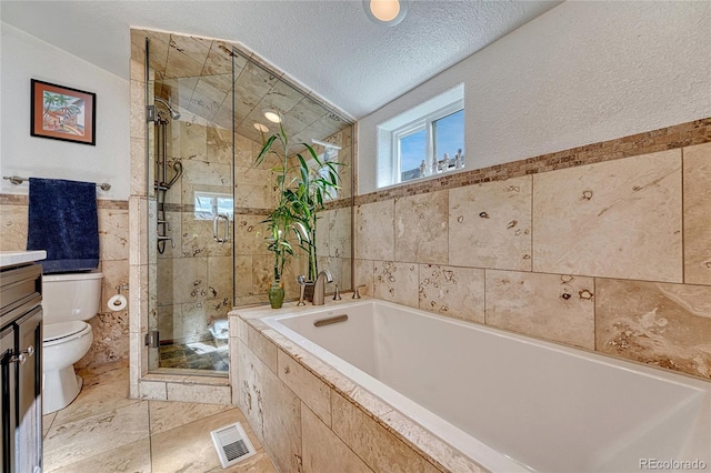 full bathroom featuring toilet, shower with separate bathtub, tile walls, a textured ceiling, and vanity