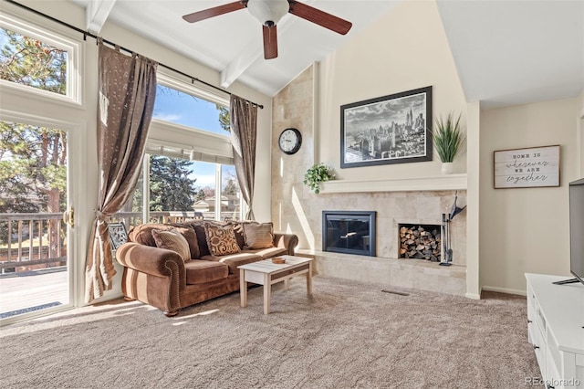 living area with visible vents, carpet, high vaulted ceiling, and a tile fireplace