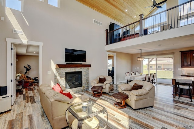 3308 County Road 19, Fort Lupton, CO 80621 - living area with high vaulted ceiling, light wood finished floors, a fireplace, ceiling fan, and wooden ceiling