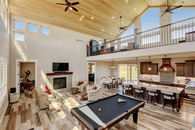 3308 County Road 19, Fort Lupton, CO 80621 - playroom featuring ceiling fan, high vaulted ceiling, light wood finished floors, a fireplace, and wooden ceiling