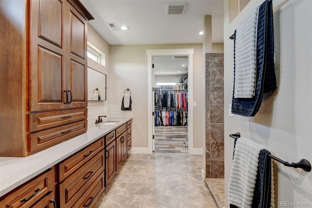 3308 County Road 19, Fort Lupton, CO 80621 - bathroom with vanity, a walk in closet, recessed lighting, and baseboards